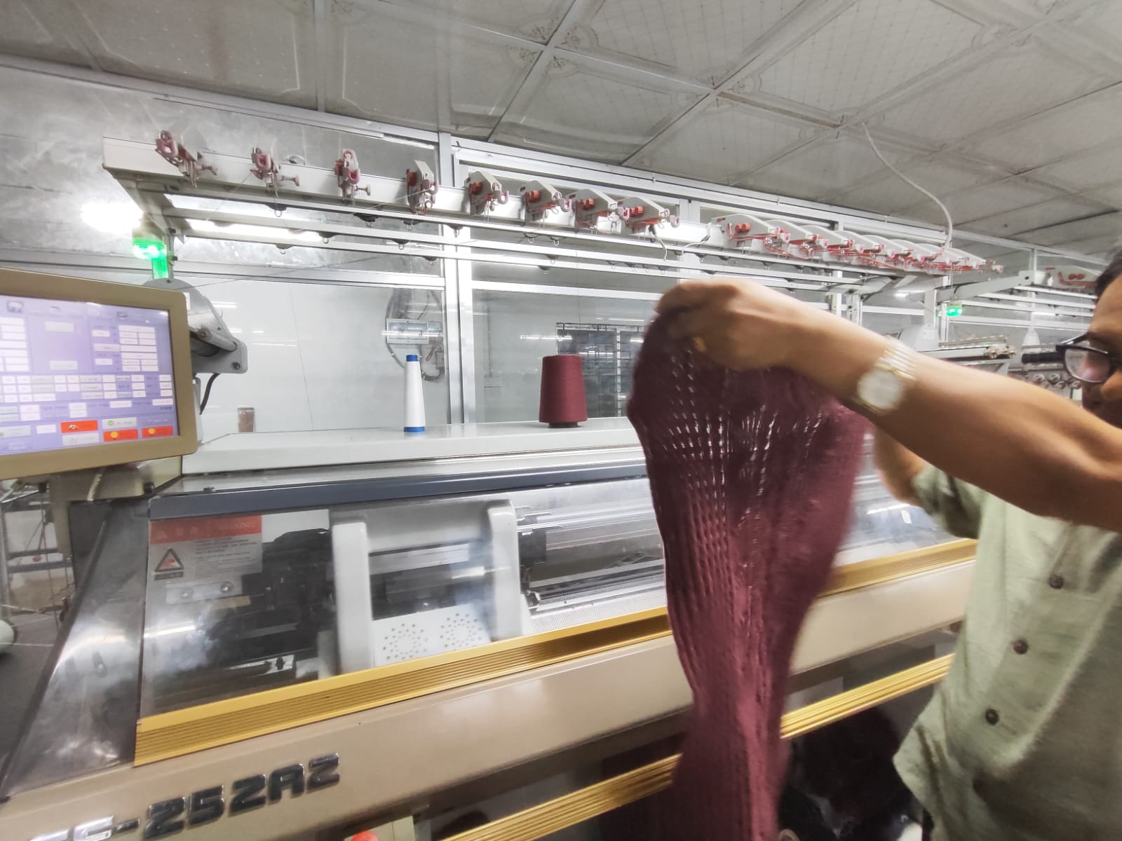 Freshly knitted sweater panel inspected on the production line